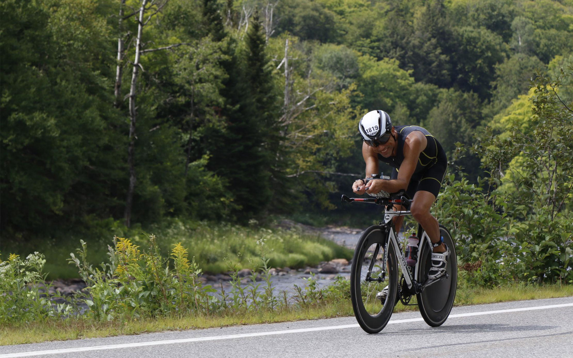 Cyclist on a time-trial bike in a forested race setting